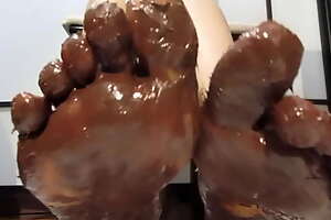 My feet with varnished nails, all covered with chocolate cream